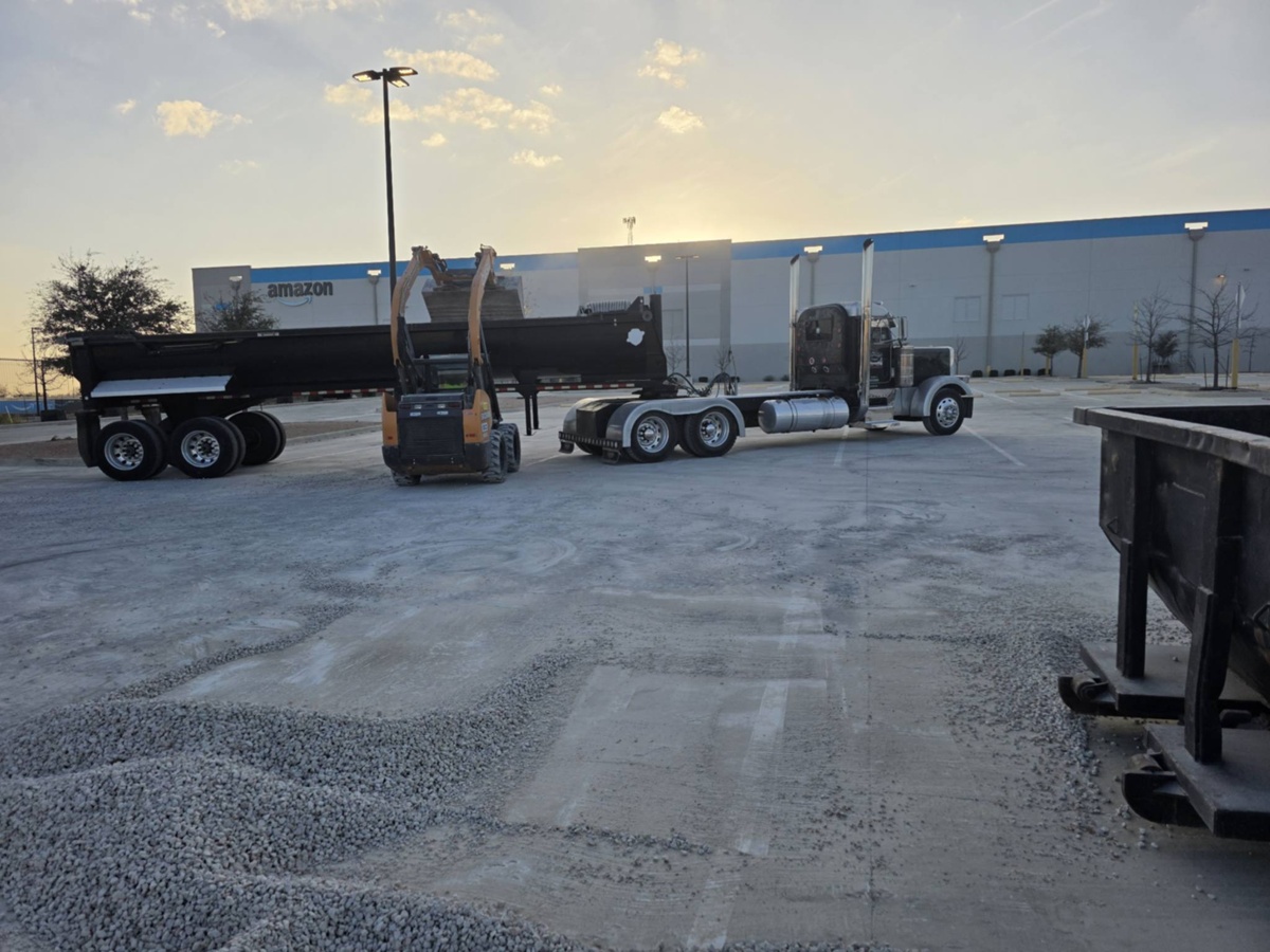 Semi truck and skid steer on commercial site