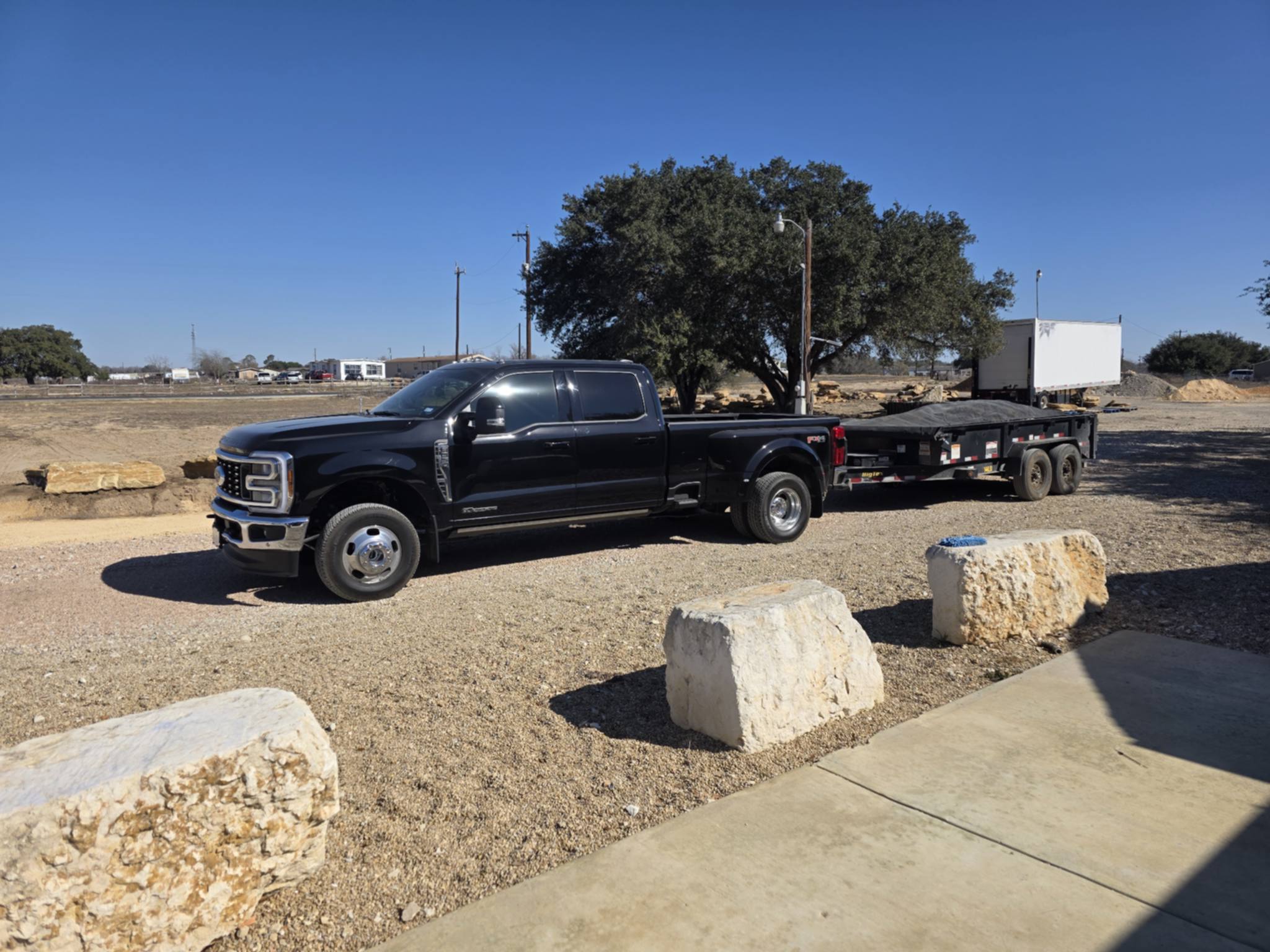 Truck and trailer parked on gravel lot
